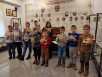 Dzieci z drewnianymi modelami w dłoniach w sali wystawowej Izby Pamięci Rodziny Maklakiewiczów